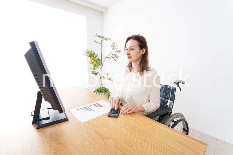 車椅子でデスクワークをする外国人の女性