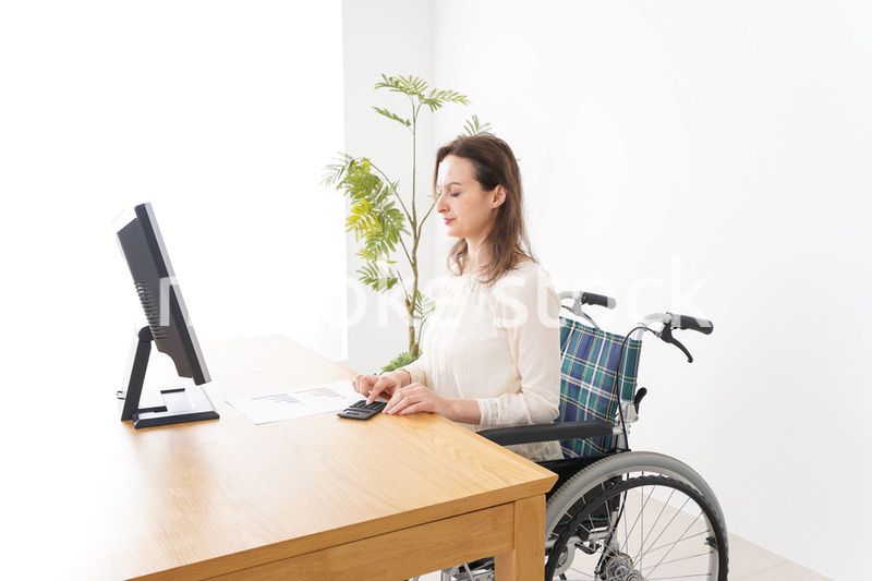 車椅子でデスクワークをする外国人の女性