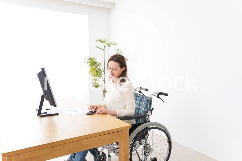 車椅子でデスクワークをする外国人の女性