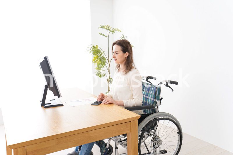 車椅子でデスクワークをする外国人の女性
