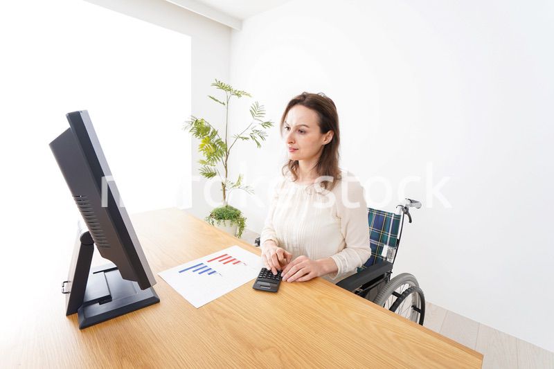 車椅子でデスクワークをする外国人の女性