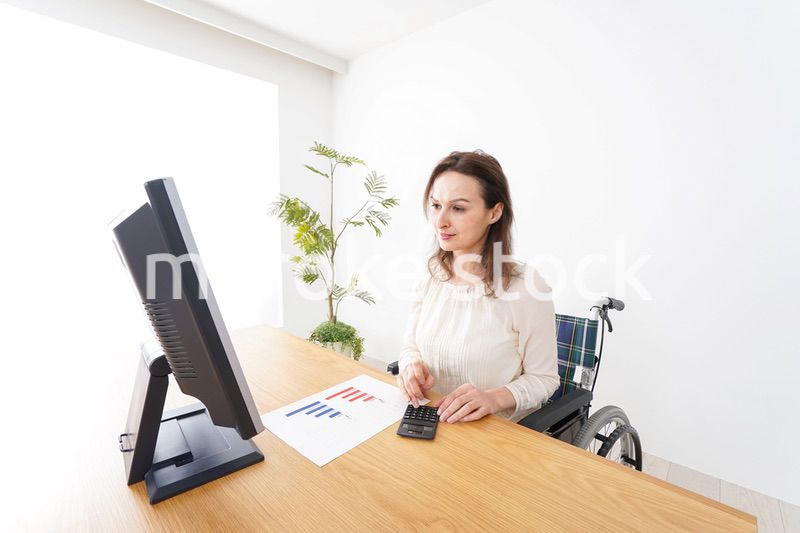 車椅子でデスクワークをする外国人の女性