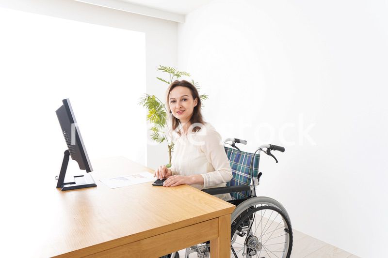 車椅子でデスクワークをする外国人の女性