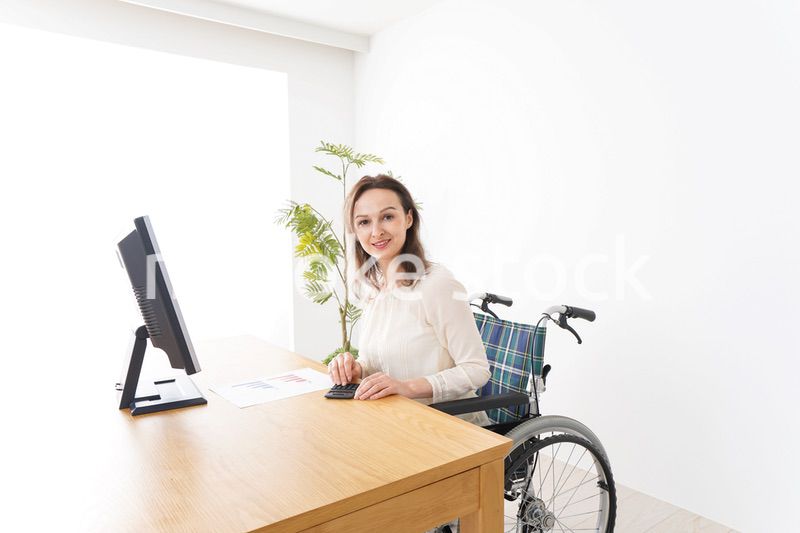 車椅子でデスクワークをする外国人の女性