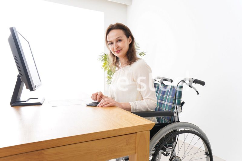 車椅子でデスクワークをする外国人の女性