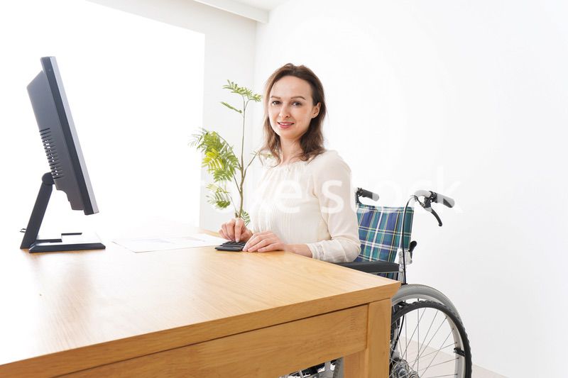 車椅子でデスクワークをする外国人の女性