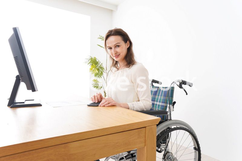 車椅子でデスクワークをする外国人の女性