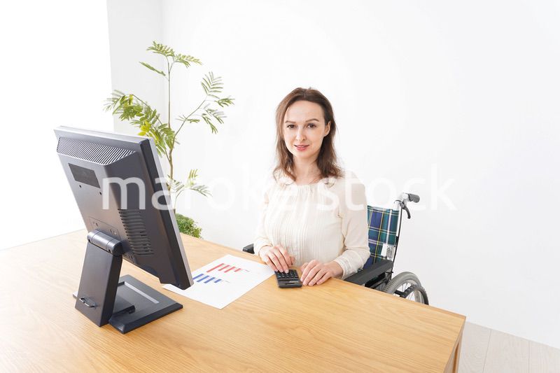 車椅子でデスクワークをする外国人の女性