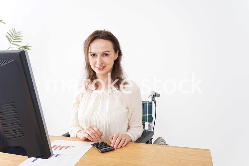 車椅子でデスクワークをする外国人の女性