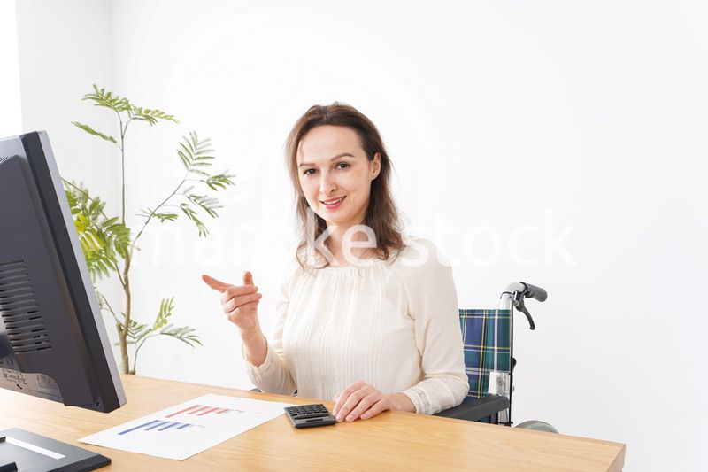 車椅子でデスクワークをする外国人の女性