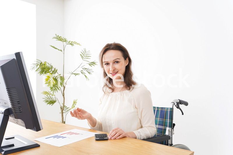 車椅子でデスクワークをする外国人の女性