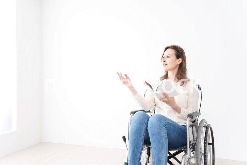 車椅子に乗り読書をする外国人の女性