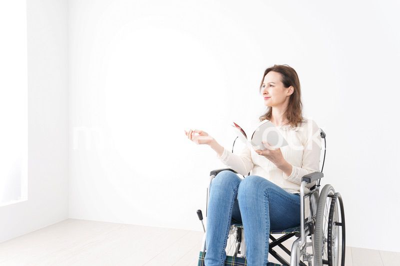 車椅子に乗り読書をする外国人の女性