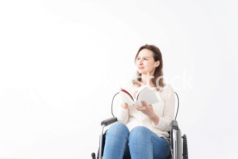 車椅子に乗り読書をする外国人の女性