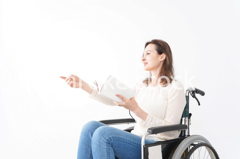 車椅子に乗り読書をする外国人の女性
