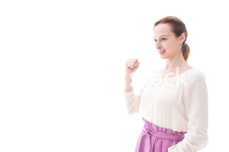 ガッツポーズをする若い女性