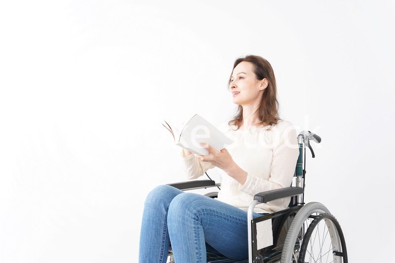 車椅子に乗り読書をする外国人の女性