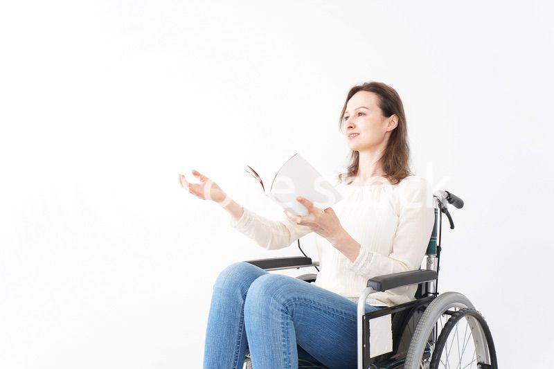 車椅子に乗り読書をする外国人の女性