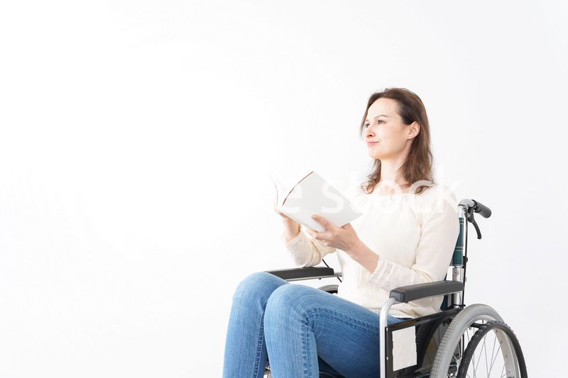 車椅子に乗り読書をする外国人の女性