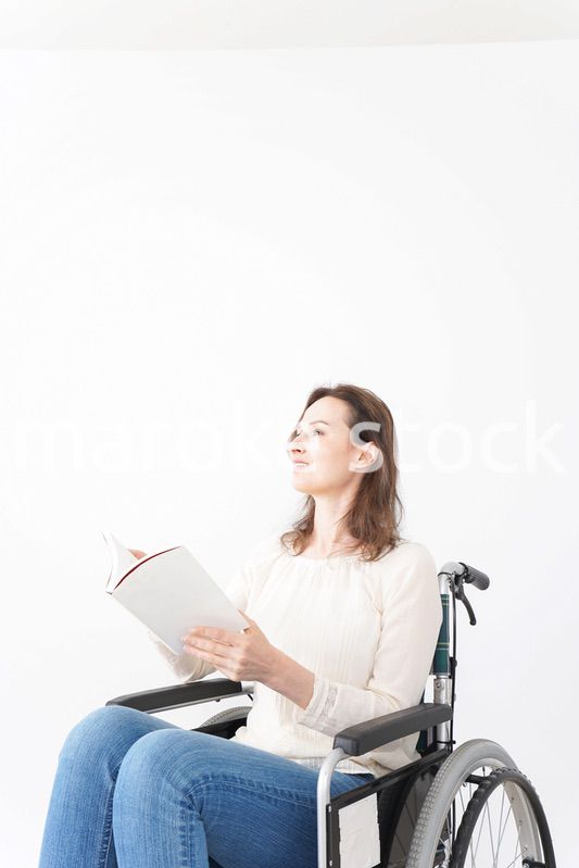 車椅子に乗り読書をする外国人の女性