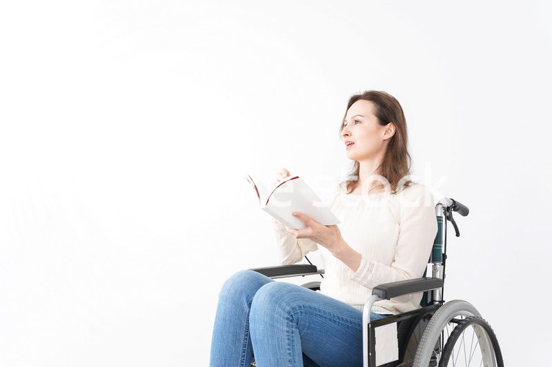 車椅子に乗り読書をする外国人の女性