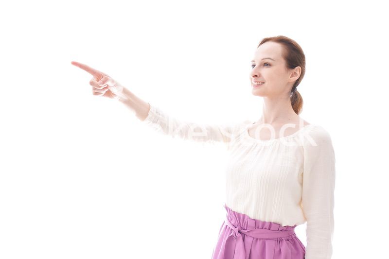 遠くを指差す若い女性
