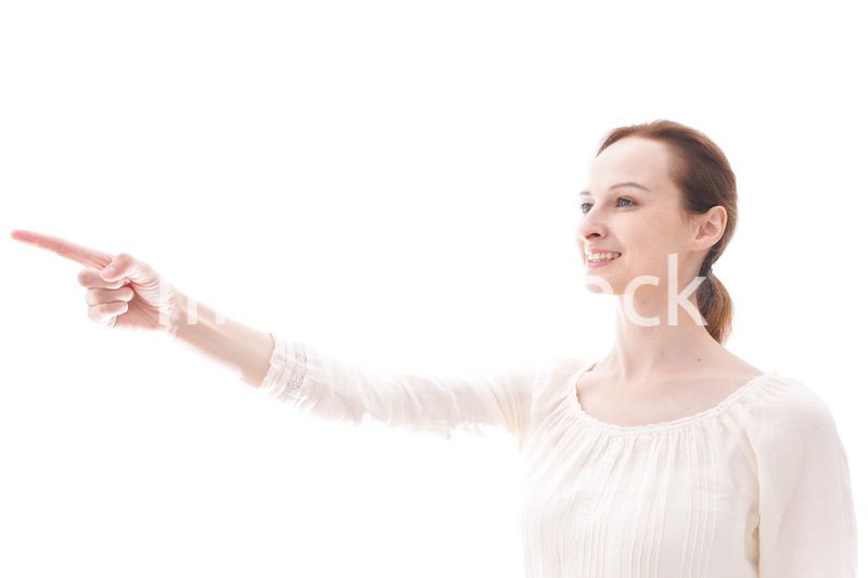 遠くを指差す若い女性