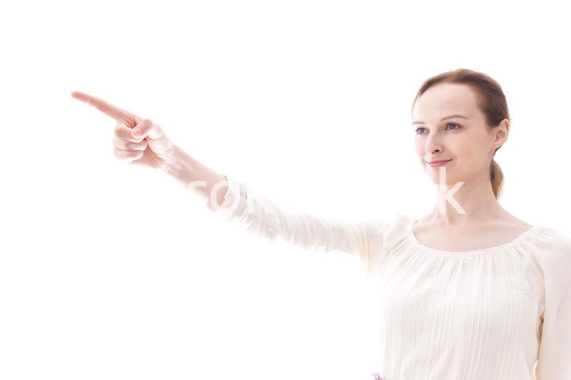 遠くを指差す若い女性