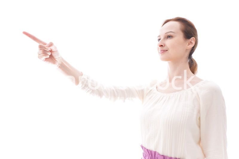 遠くを指差す若い女性