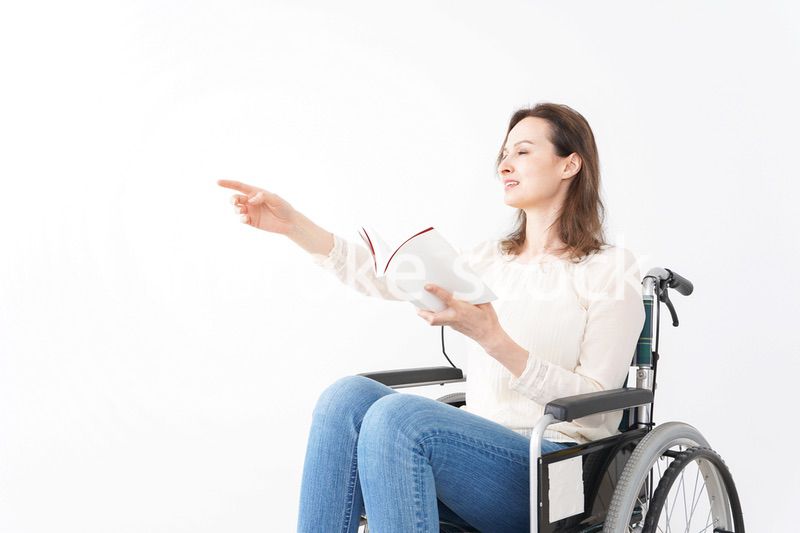 車椅子に乗り読書をする外国人の女性