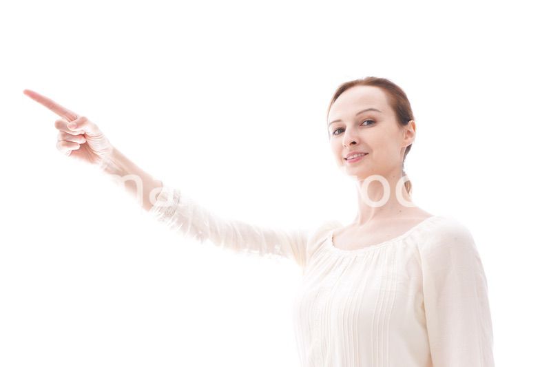 遠くを指差す若い女性