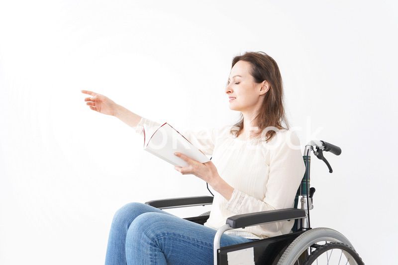 車椅子に乗り読書をする外国人の女性
