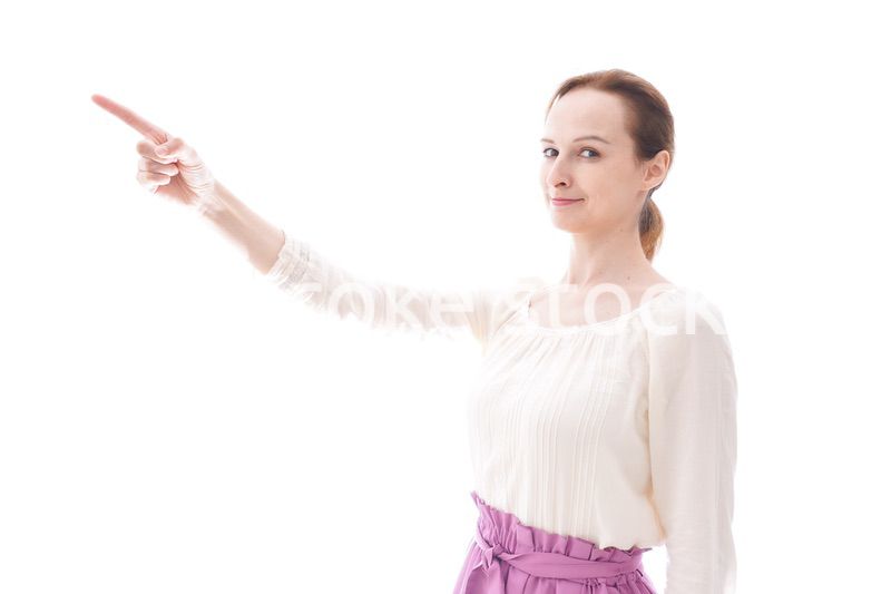 遠くを指差す若い女性