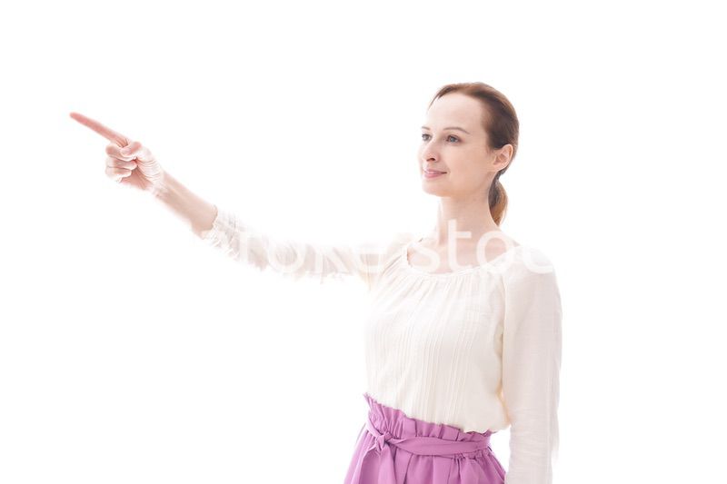 遠くを指差す若い女性