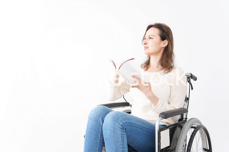 車椅子に乗り読書をする外国人の女性