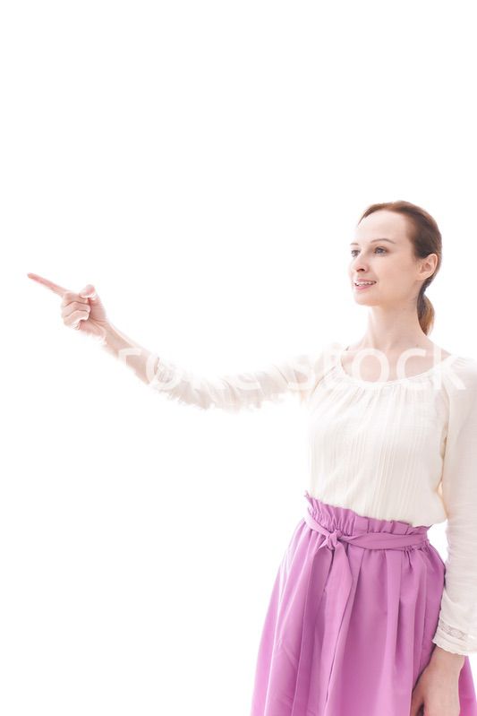遠くを指差す若い女性