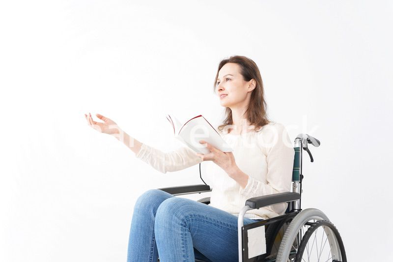 車椅子に乗り読書をする外国人の女性