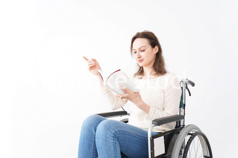 車椅子に乗り読書をする外国人の女性