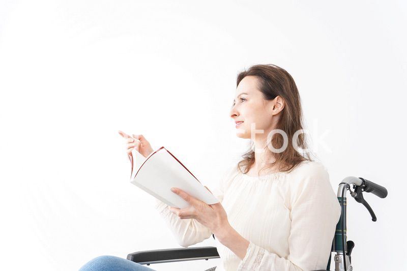 車椅子に乗り読書をする外国人の女性