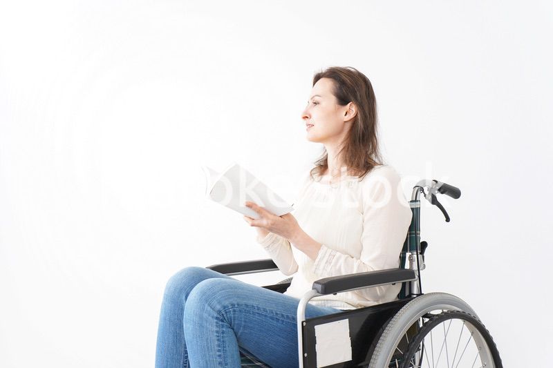 車椅子に乗り読書をする外国人の女性