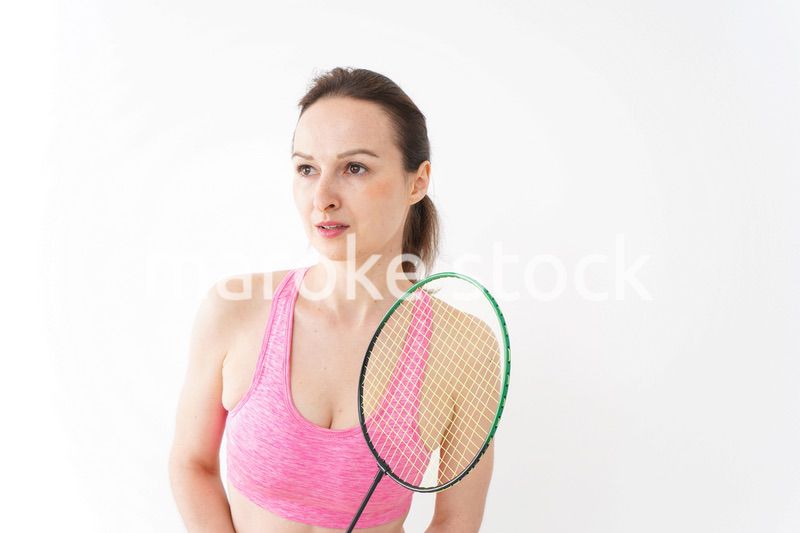 スポーツウェアを着てバドミントンをする外国人の女性