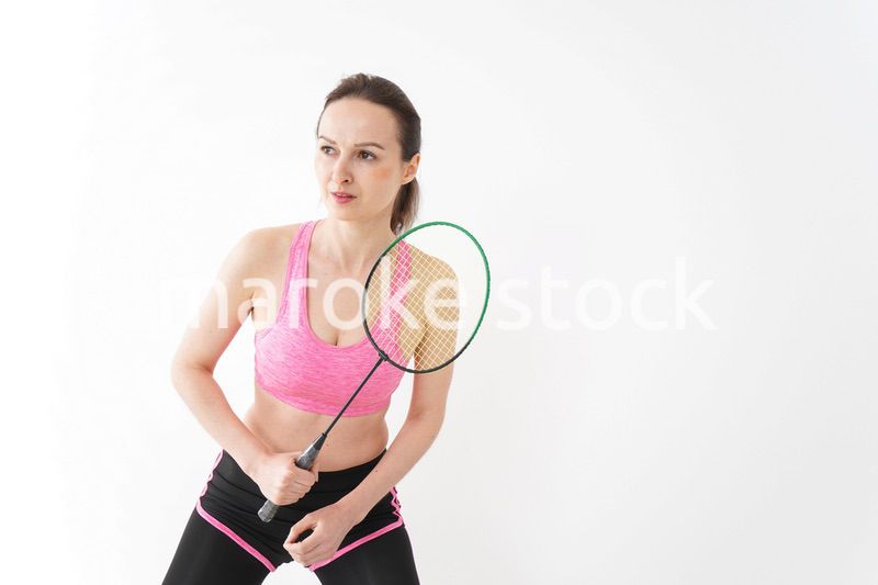 スポーツウェアを着てバドミントンをする外国人の女性