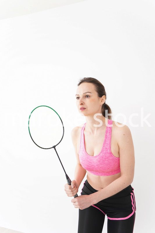 スポーツウェアを着てバドミントンをする外国人の女性