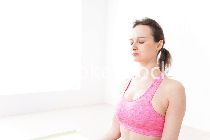 スポーツウェアを着てヨガをする外国人の女性