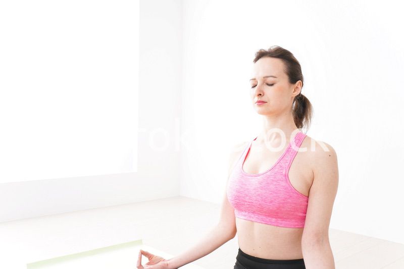 スポーツウェアを着てヨガをする外国人の女性