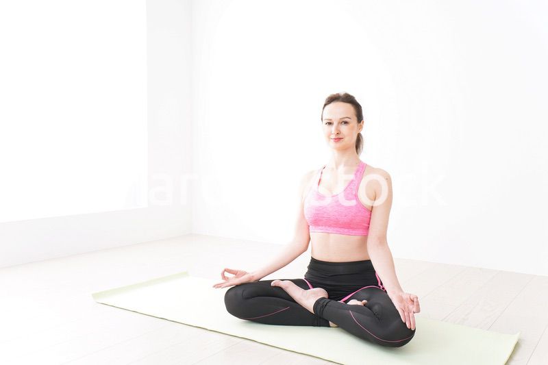 スポーツウェアを着てヨガをする外国人の女性