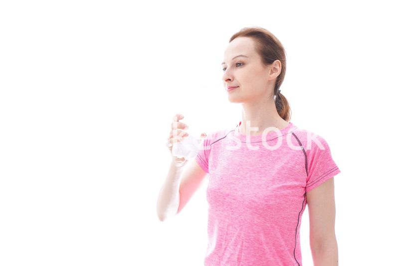 水分補給をするスポーツウェアを着た若い女性