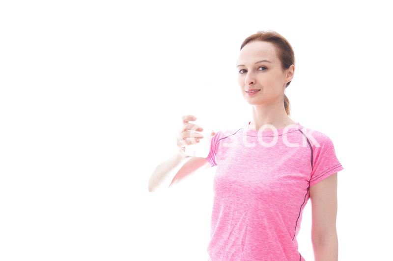 水分補給をするスポーツウェアを着た若い女性