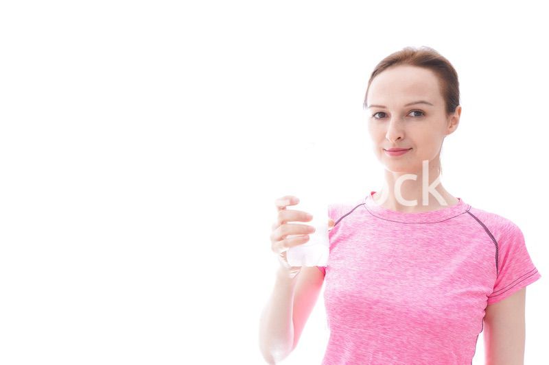 水分補給をするスポーツウェアを着た若い女性