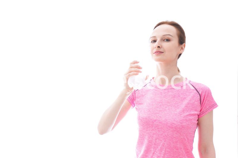水分補給をするスポーツウェアを着た若い女性